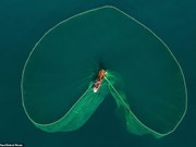 组图：越南渔民在海上抛渔网时撒出的迷人画面