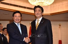 越南政府副总理兼外长范平明在东京会见日本高级领导和老挝总理通伦