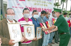 朔庄省边防部队向渔民赠送国旗和胡志明主席肖像