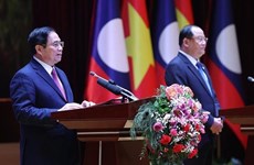 越南政府总理范明政与老挝总理宋赛·西潘敦共同主持“2022年越老、老越团结友好年”总结大会