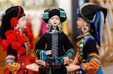 组图：热爱民族传统娃娃服饰制作的画家 
