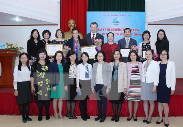越南妇女联合会向国内外专家授予“致力于越南妇女的发展”纪念章 hinh anh 1
