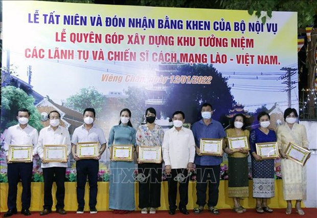 老挝向为老挝爱心慈善活动作出贡献的越南人集体和个人颁发荣誉证书 hinh anh 1