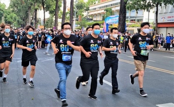 胡志明市青年参加跑步比赛 积极响应2022年“地球一小时”活动 hinh anh 1
