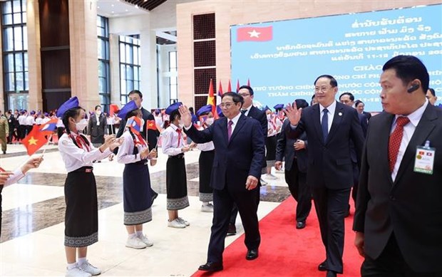 越南政府总理范明政与老挝总理宋赛·西潘敦共同主持“2022年越老、老越团结友好年”总结大会 hinh anh 1
