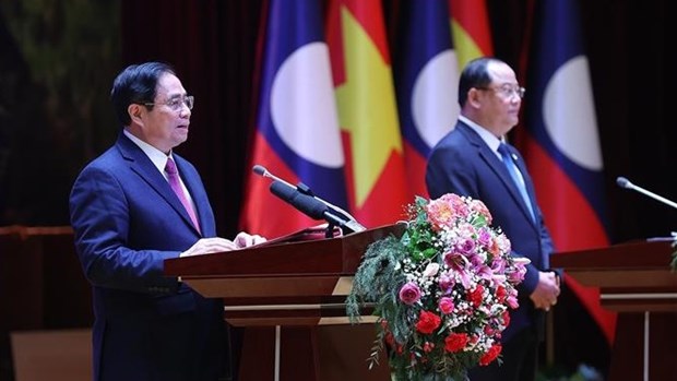 越南政府总理范明政与老挝总理宋赛·西潘敦共同主持“2022年越老、老越团结友好年”总结大会 hinh anh 2