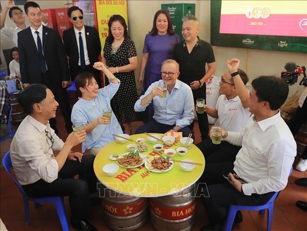 澳大利亚总理安东尼·阿尔巴尼斯喝河内啤酒品尝河内传统面包 hinh anh 2