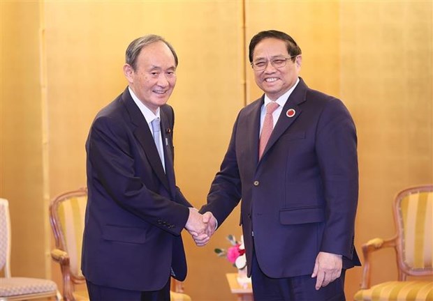 越南政府总理范明政会见日本前首相菅义伟和新加坡总理李显龙 hinh anh 1